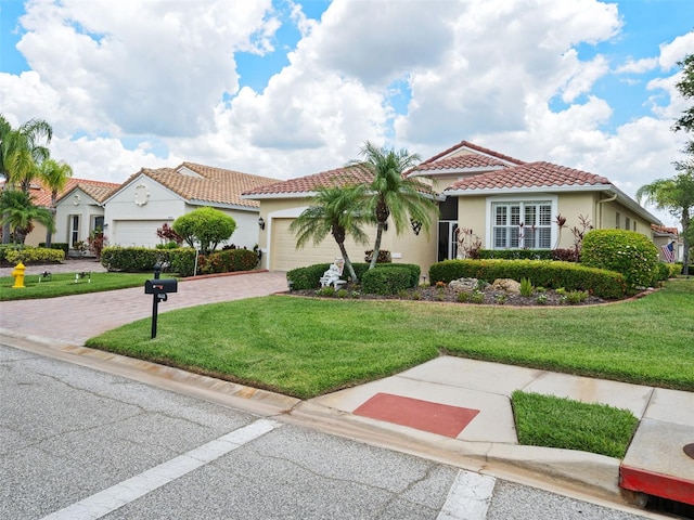 mediterranean / spanish-style home featuring a garage and a front lawn