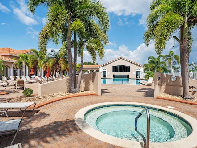 view of swimming pool featuring a patio and a hot tub