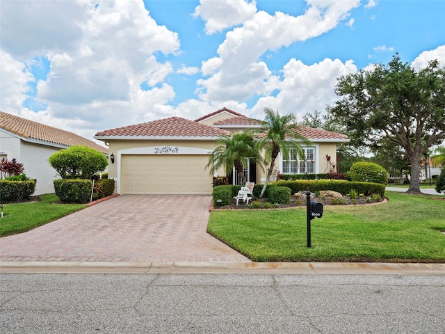 mediterranean / spanish house featuring a front yard and a garage