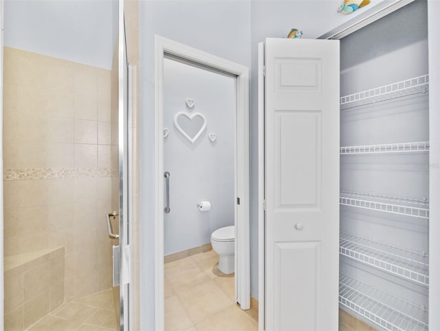 bathroom featuring toilet, tile patterned flooring, and a shower with door