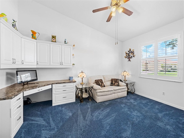 office space with lofted ceiling, dark carpet, built in desk, and ceiling fan