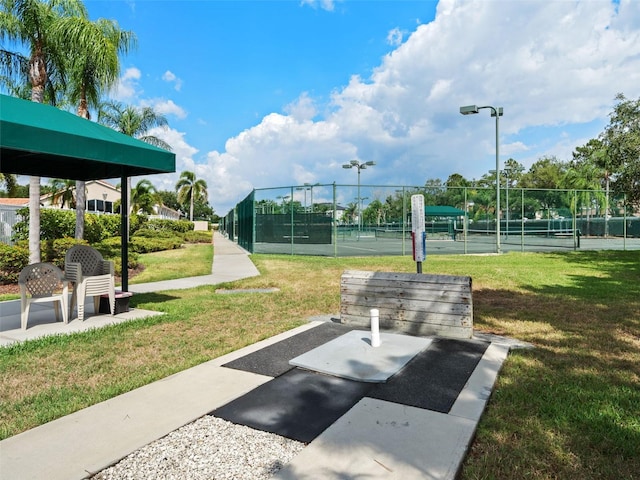 surrounding community with a yard and tennis court