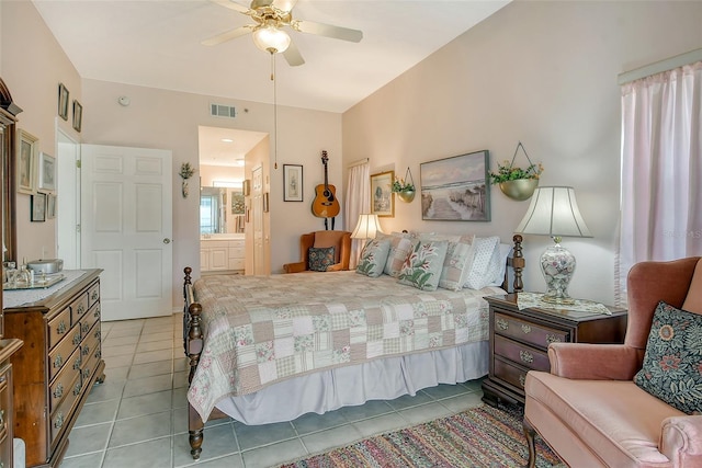 tiled bedroom featuring ceiling fan and ensuite bath