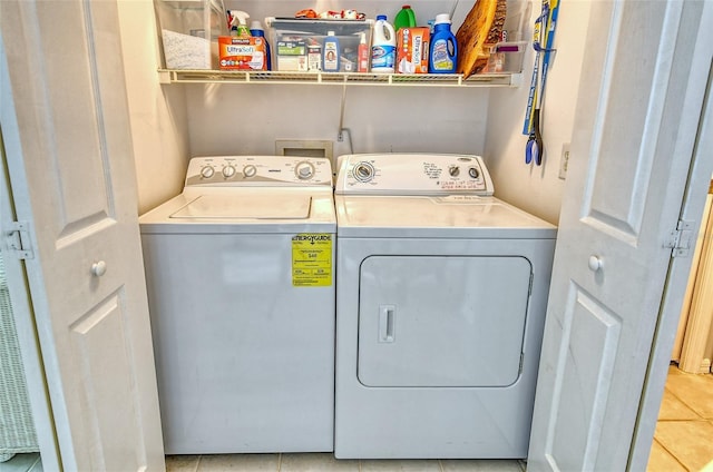 washroom with light tile patterned floors and washing machine and clothes dryer