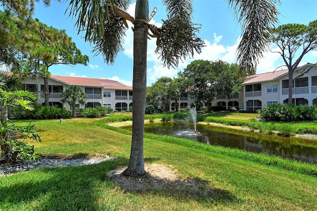 view of home's community with a lawn and a water view