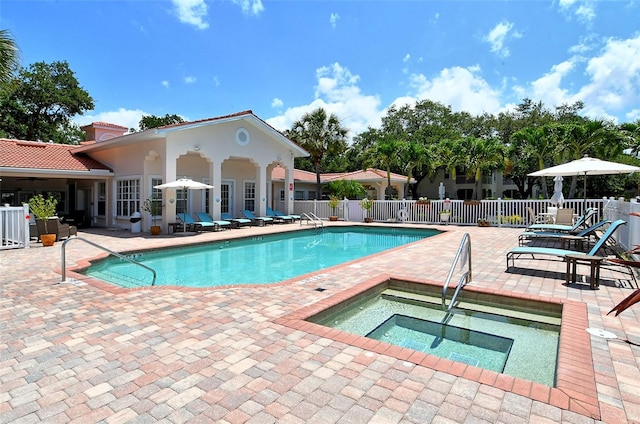 view of swimming pool with a patio and a hot tub