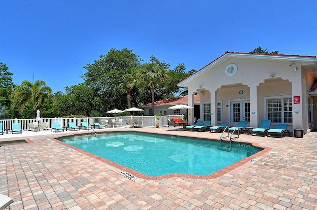 view of swimming pool with french doors and a patio