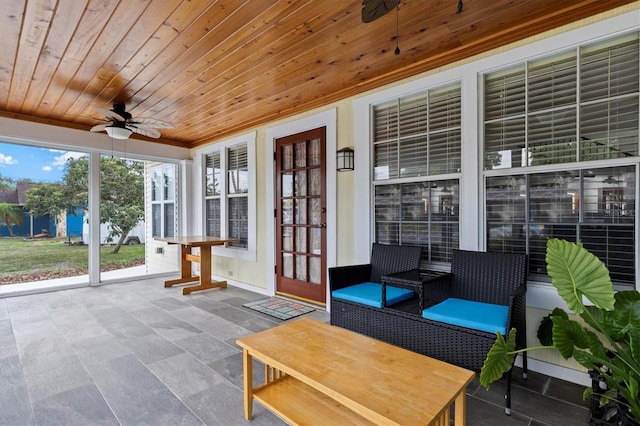 unfurnished sunroom featuring ceiling fan and wood ceiling