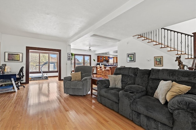 living room with a textured ceiling and light wood-type flooring