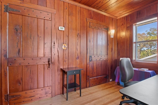 home office with wood ceiling, wooden walls, and light hardwood / wood-style floors