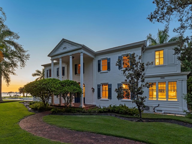 greek revival inspired property featuring ac unit and a yard