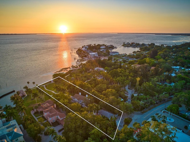 aerial view at dusk featuring a water view