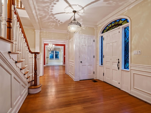 4521 Bay Shore Rd, Sarasota, FL 34234 - foyer entrance featuring ornamental molding, a decorative wall, a notable chandelier, and light wood finished floors