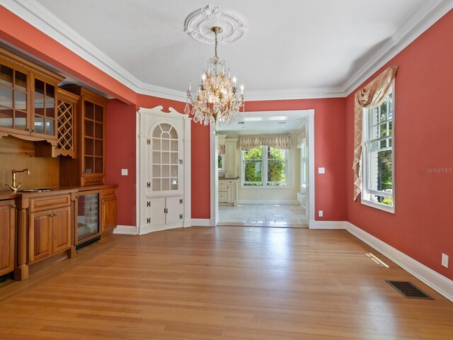 4521 Bay Shore Rd, Sarasota, FL 34234 - unfurnished dining area featuring an inviting chandelier, wine cooler, light wood finished floors, and visible vents