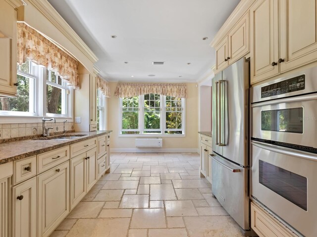 4521 Bay Shore Rd, Sarasota, FL 34234 - kitchen with a sink, stone tile flooring, stainless steel appliances, baseboards, and cream cabinetry