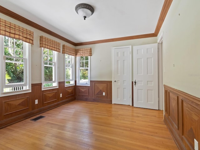 4521 Bay Shore Rd, Sarasota, FL 34234 - spare room with a wainscoted wall, ornamental molding, light wood finished floors, and visible vents