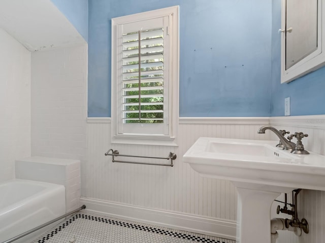 4521 Bay Shore Rd, Sarasota, FL 34234 - bathroom featuring tile patterned floors, wainscoting, and bathing tub / shower combination
