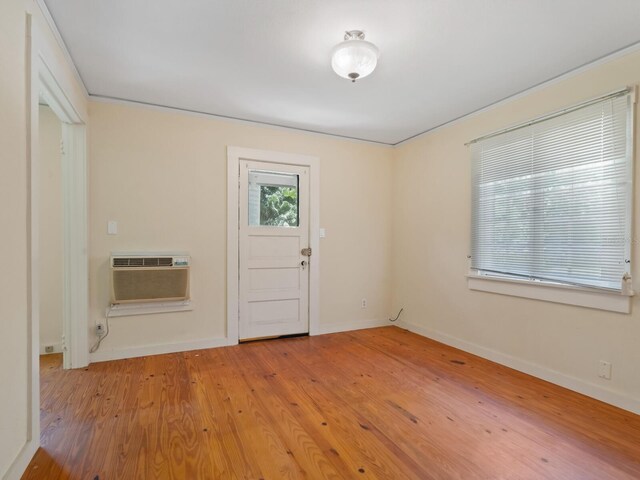 4521 Bay Shore Rd, Sarasota, FL 34234 - entrance foyer featuring baseboards, a wall mounted AC, and light wood finished floors
