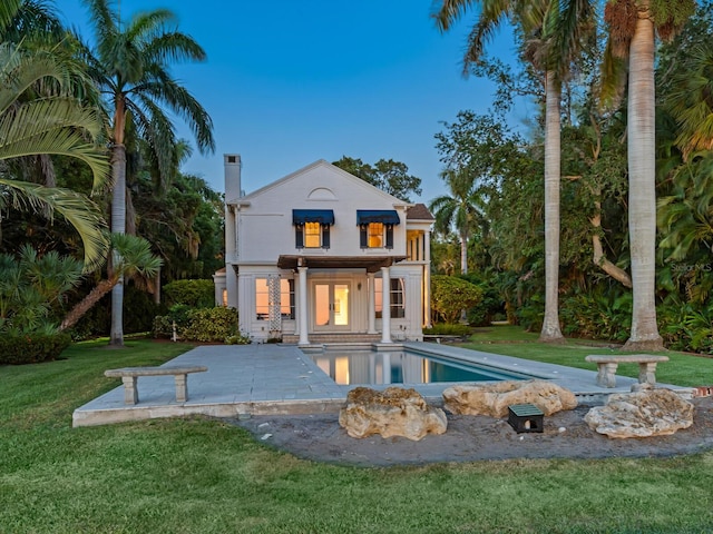 4521 Bay Shore Rd, Sarasota, FL 34234 - back of house featuring a lawn, a chimney, and an outdoor pool