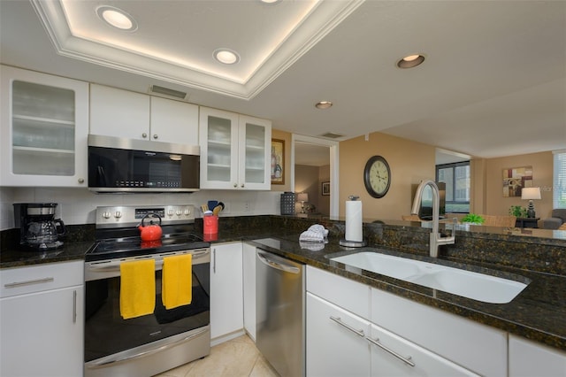 kitchen with a raised ceiling, sink, white cabinetry, and stainless steel appliances