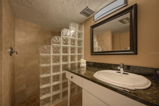 5920 Midnight Pass Rd Unit 104, Sarasota, FL 34242 - bathroom featuring a walk in shower, a textured ceiling, and vanity