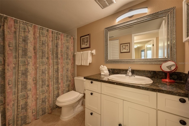 bathroom with tile patterned flooring, vanity, and toilet