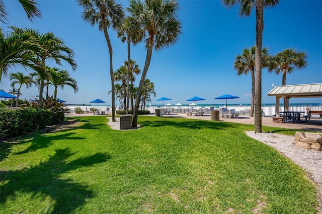 view of community featuring a lawn, a water view, and a patio