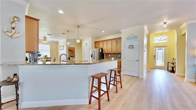 kitchen with ceiling fan, stainless steel fridge, tasteful backsplash, and light wood-type flooring