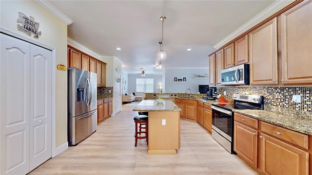 kitchen featuring a center island, light hardwood / wood-style floors, appliances with stainless steel finishes, kitchen peninsula, and tasteful backsplash