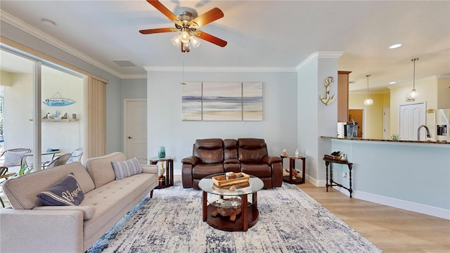 living room with ceiling fan, sink, ornamental molding, and hardwood / wood-style flooring