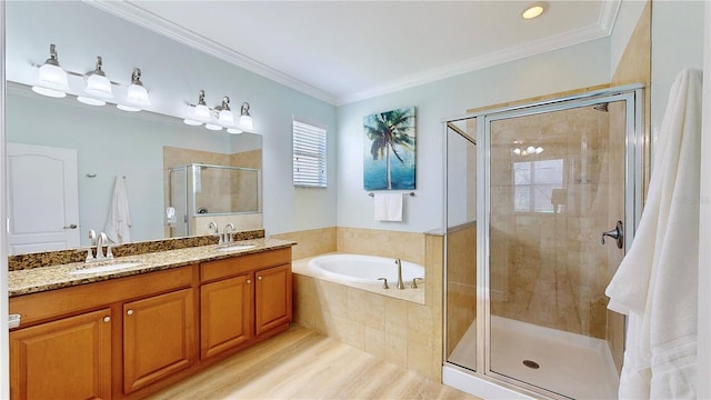 bathroom featuring ornamental molding, vanity with extensive cabinet space, separate shower and tub, and double sink