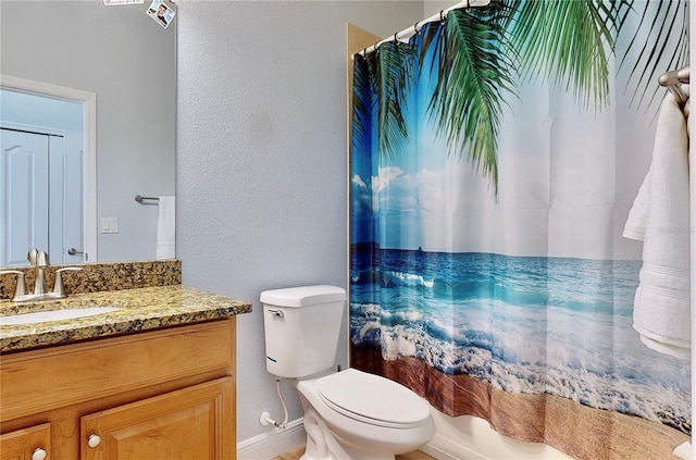 bathroom featuring vanity with extensive cabinet space and toilet