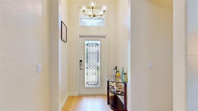 entryway with a notable chandelier and wood-type flooring