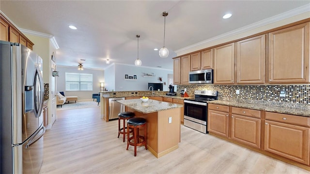 kitchen featuring ceiling fan, light hardwood / wood-style floors, kitchen peninsula, a breakfast bar, and appliances with stainless steel finishes