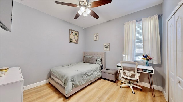 bedroom with a closet, ceiling fan, and light wood-type flooring