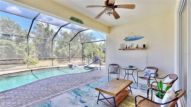 view of pool with a patio area, glass enclosure, and ceiling fan