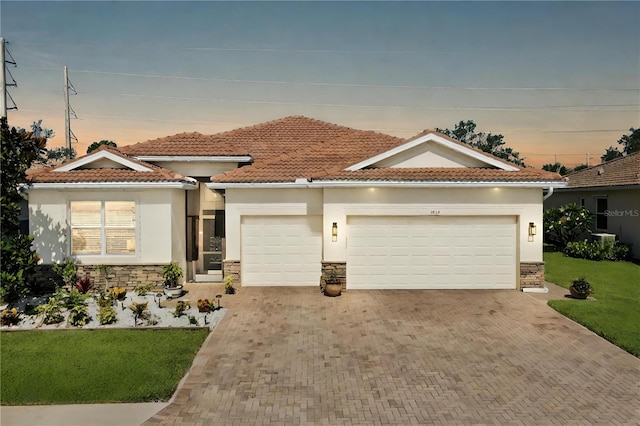 mediterranean / spanish house featuring a garage and a lawn