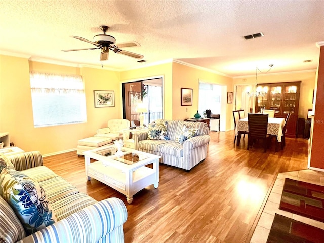 living room with a textured ceiling, ornamental molding, ceiling fan with notable chandelier, and hardwood / wood-style flooring