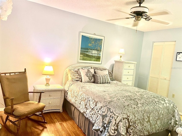 bedroom with ceiling fan, a textured ceiling, a closet, and light hardwood / wood-style flooring