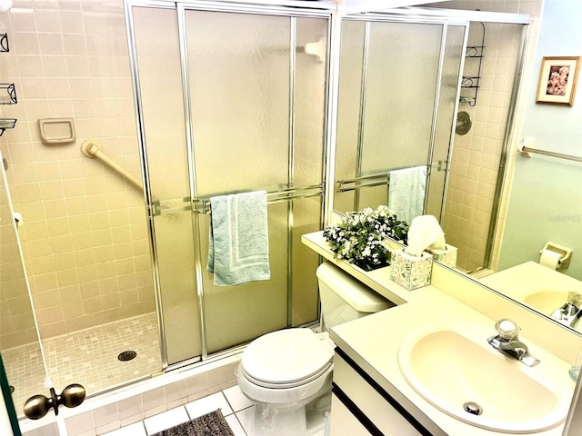 bathroom featuring tile patterned floors, walk in shower, toilet, and vanity