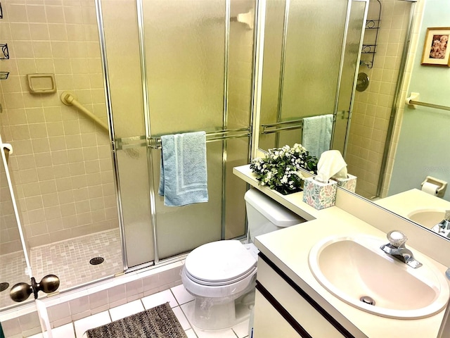 bathroom with vanity, toilet, tile patterned floors, and a shower with door