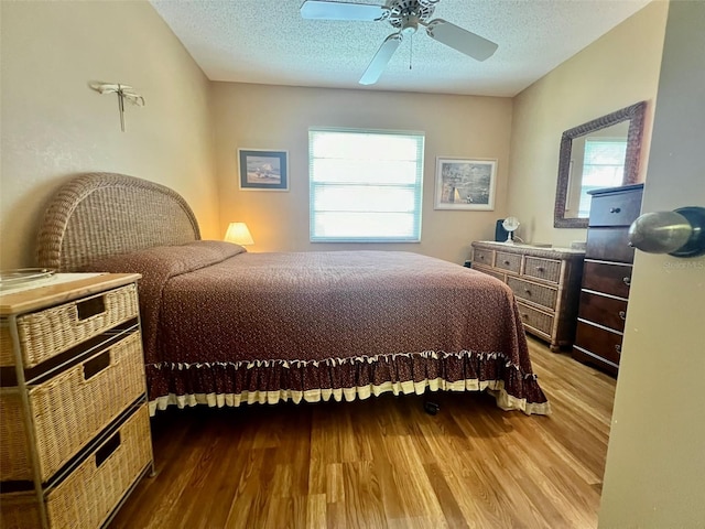 bedroom featuring a textured ceiling, ceiling fan, and hardwood / wood-style floors