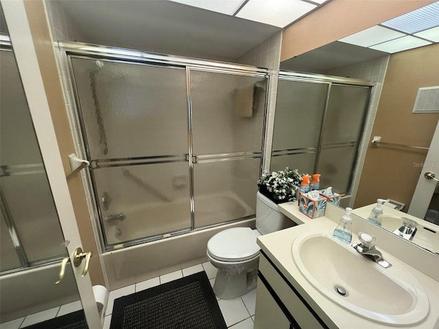 full bathroom featuring toilet, tile patterned flooring, enclosed tub / shower combo, and vanity