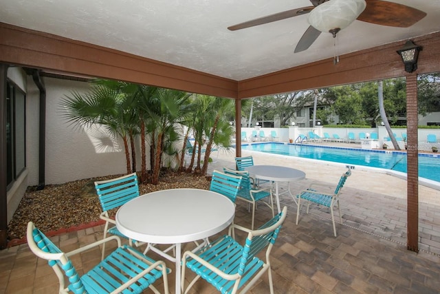 view of patio featuring ceiling fan and a community pool