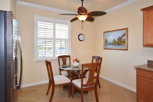 dining room with ornamental molding, light tile patterned flooring, and baseboards