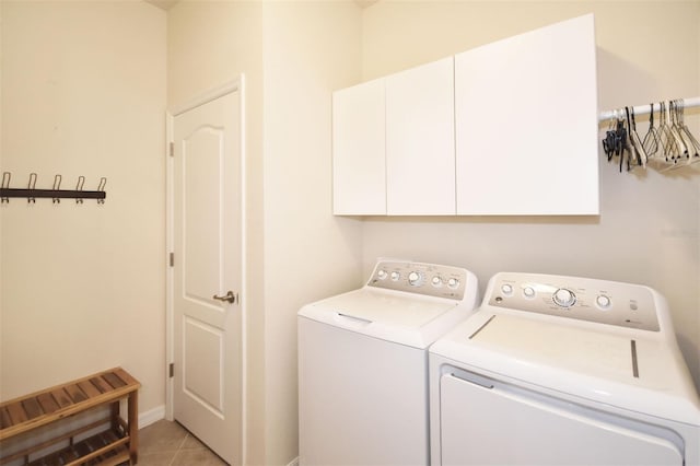 laundry room with light tile patterned flooring, cabinet space, baseboards, and separate washer and dryer