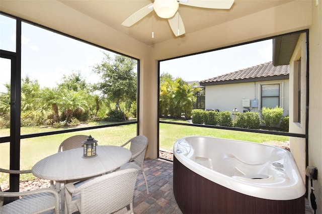 sunroom / solarium featuring a ceiling fan and a jacuzzi