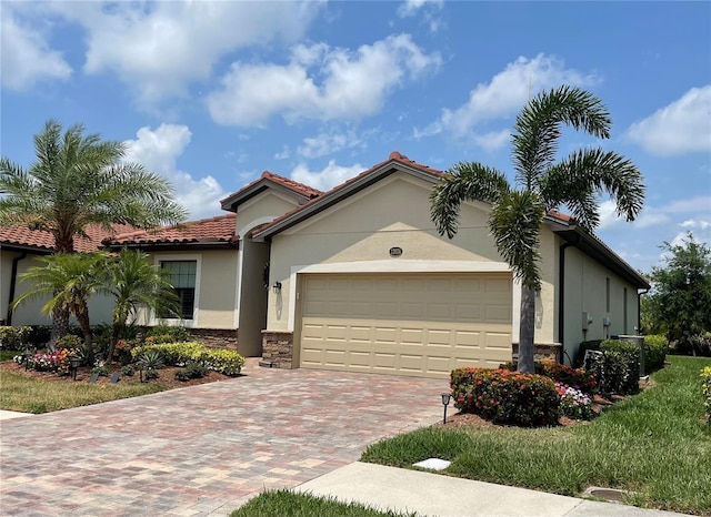 view of front facade with a garage, a tiled roof, stone siding, decorative driveway, and stucco siding