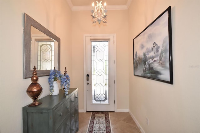 foyer with light tile patterned floors, ornamental molding, an inviting chandelier, and baseboards