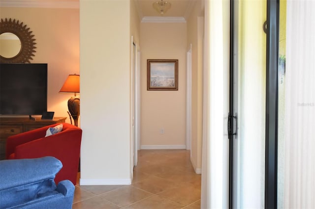 hallway with ornamental molding, baseboards, and light tile patterned floors